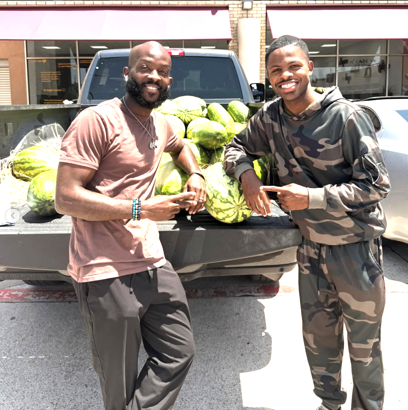 Supporters pointing at fresh watermelons loaded in a pickup truck