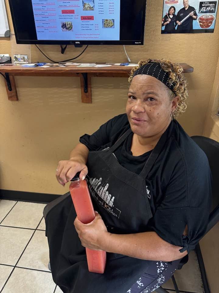 Kitchen owner with a bottle of Straight D.R.O.P. watermelon juice